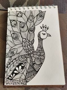 a black and white drawing of a peacock on a piece of paper with pen in it