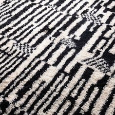 a black and white rug with an abstract design on it's surface, close up