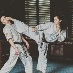 two people doing karate moves in a room