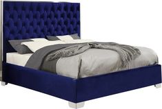 a bed with blue upholstered headboard and pillows