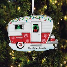 an ornament shaped like a camper is hanging from a christmas tree with lights