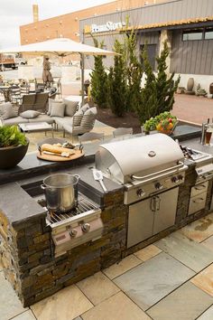 an outdoor kitchen with grill and seating area