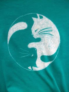 a person wearing a green shirt with a white cat on it's chest and back