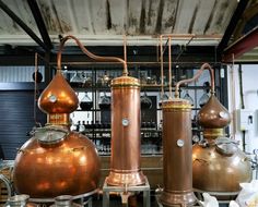 three large copper pots sitting next to each other on top of a table in a room