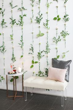 a white bench sitting next to a wall covered in plants