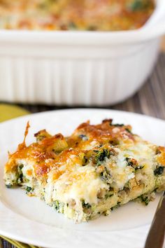 a slice of quiche with cheese and spinach on a plate next to a fork