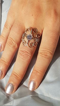 a close up of a person's hand with a ring on their finger and nails