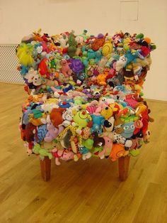 a chair covered in stuffed animals sitting on top of a hard wood floor