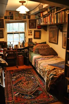 a bedroom with a bed, desk and bookshelf full of bookcases