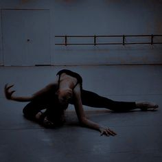 a woman is doing a handstand on the floor in an empty room with no one around her