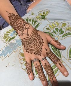 a woman's hand with henna tattoos on it