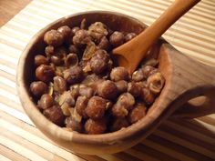 a wooden bowl filled with nuts on top of a table