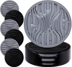 four round coasters sitting on top of a black stand with five circles around them