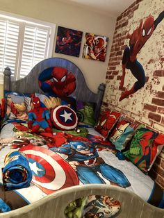 a bed with spiderman and captain america sheets in a child's bedroom area