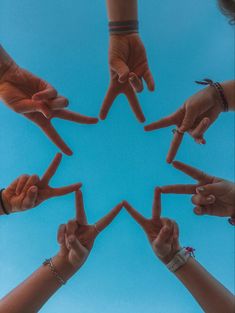 several people holding their hands together in the shape of a star