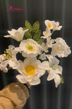 a hand holding a bouquet of white flowers