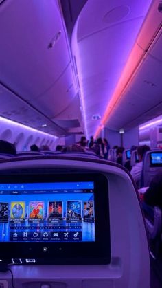 an airplane with many people on the seats and in the back, there is a large screen