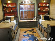 a bedroom with two twin beds and a desk in front of a window that has bookshelves on it