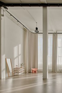 an empty room with white walls and curtains