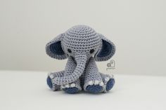 a crocheted elephant sitting on top of a white table