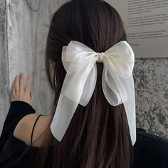 a woman with long hair wearing a white bow