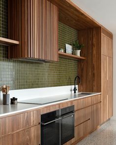 a modern kitchen with wooden cabinets and white counter tops, black appliances and dishwasher