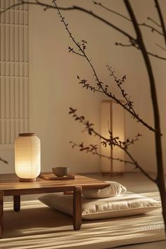 a table with a vase on it next to a lamp and some branches in the background