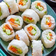 sushi rolls on a plate with chopsticks next to it