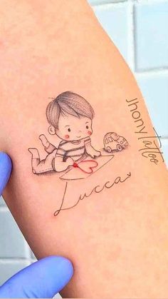 a person with a tattoo on their arm holding up a small child's hand