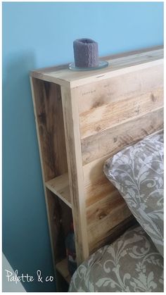 a bed with a wooden headboard and night stand on it's side next to a blue wall