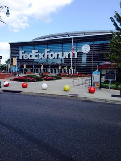 an outside view of the fedex forum with balls on the ground and in front