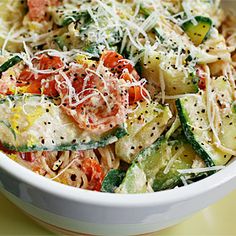 a white bowl filled with pasta and veggies covered in parmesan cheese