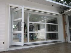 two people are standing in the doorway of a house that is being renovated with new windows