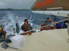 three men sitting on the back of a boat