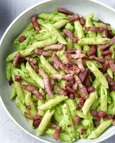 a white bowl filled with broccoli and bacon on top of a gray table