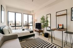 a bedroom with a bed, desk and television in it