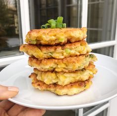 a stack of food sitting on top of a white plate next to a windowsill