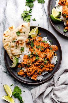 two plates filled with chicken tikka and rice, garnished with cilantro