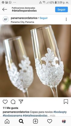 two wine glasses sitting on top of a table next to each other with white lace