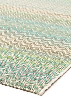 a close up view of a blue and green rug on a white surface with an interesting pattern