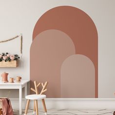 a living room with pink and orange wallpaper on the walls, two stools and a white table in front of it