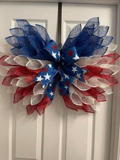 a red, white and blue wreath with stars on the top is hanging on a door