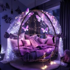 a bed with purple sheets and pillows in a room filled with butterflies on the walls