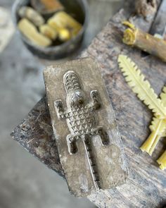 a metal object sitting on top of a wooden table next to other tools and materials