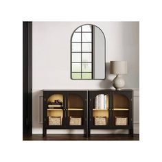 the sideboard has two baskets on it and is next to a mirror with an arched window