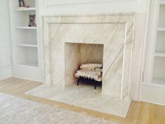 a white fireplace in a living room with built - in bookshelves and shelving