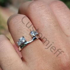 a woman's hand with a diamond ring on it