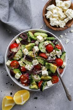 a salad with cucumbers, tomatoes, olives, and feta cheese