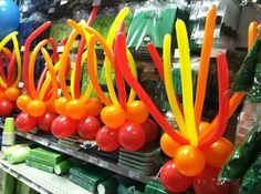 plastic balloons are lined up on the shelves in a store, with other items behind them