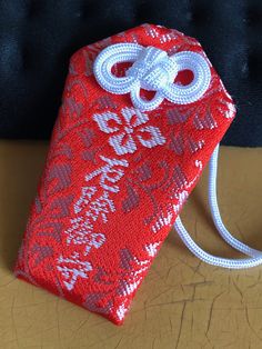 a red and white purse sitting on top of a wooden table